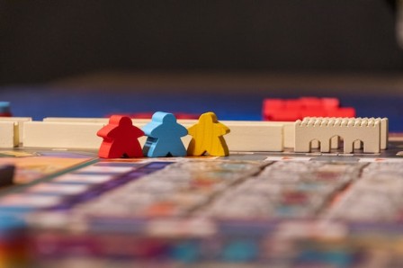 Three meeples on a game board